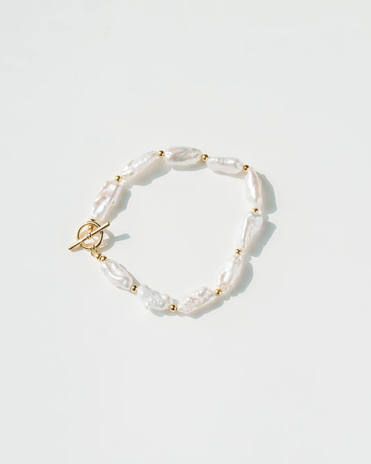 Pearl bracelet with gold accents on a white background
